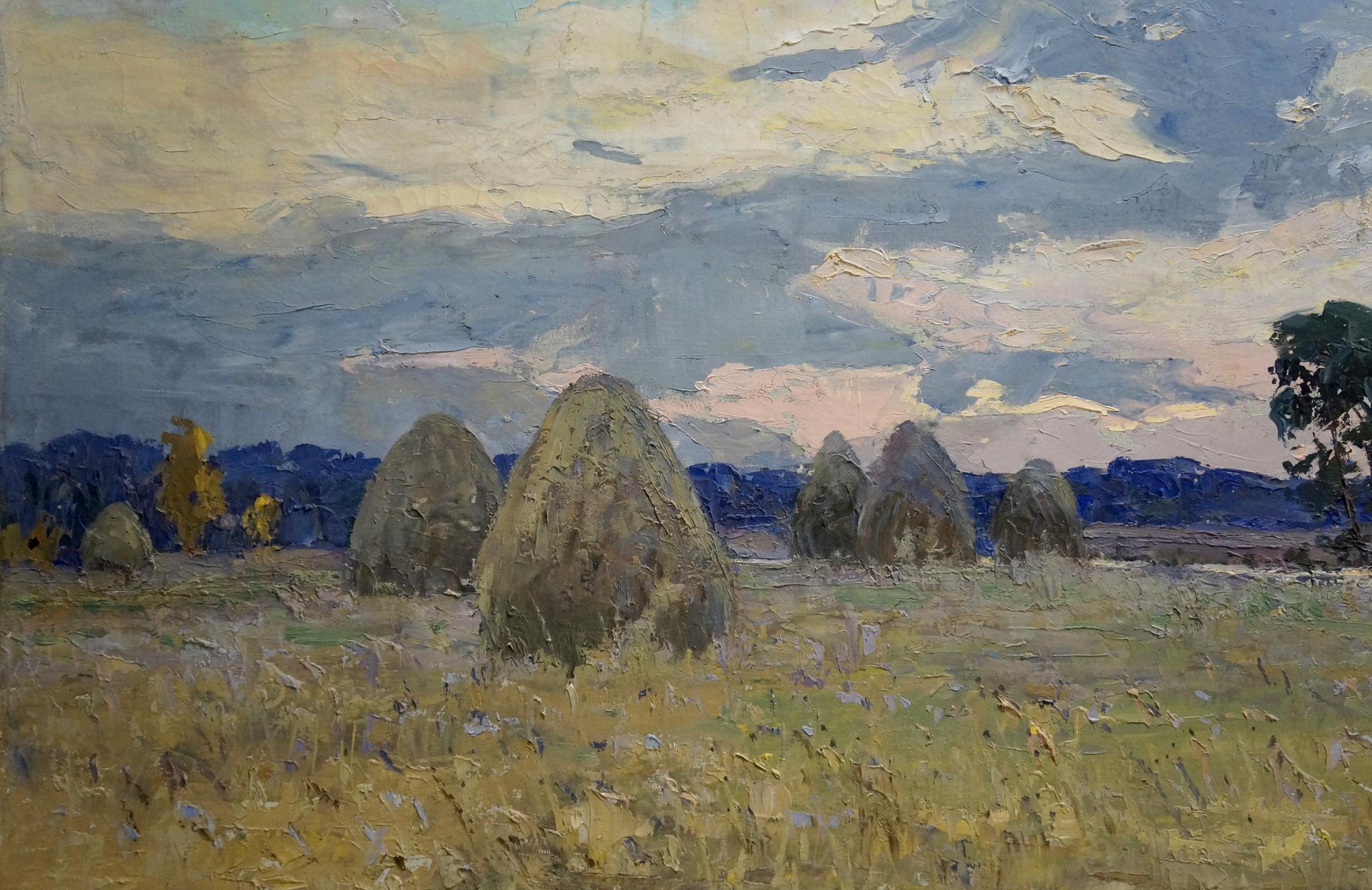 Oil painting by Tyukha Ivan Andreevich: golden hay bales under dramatic cloudy sky