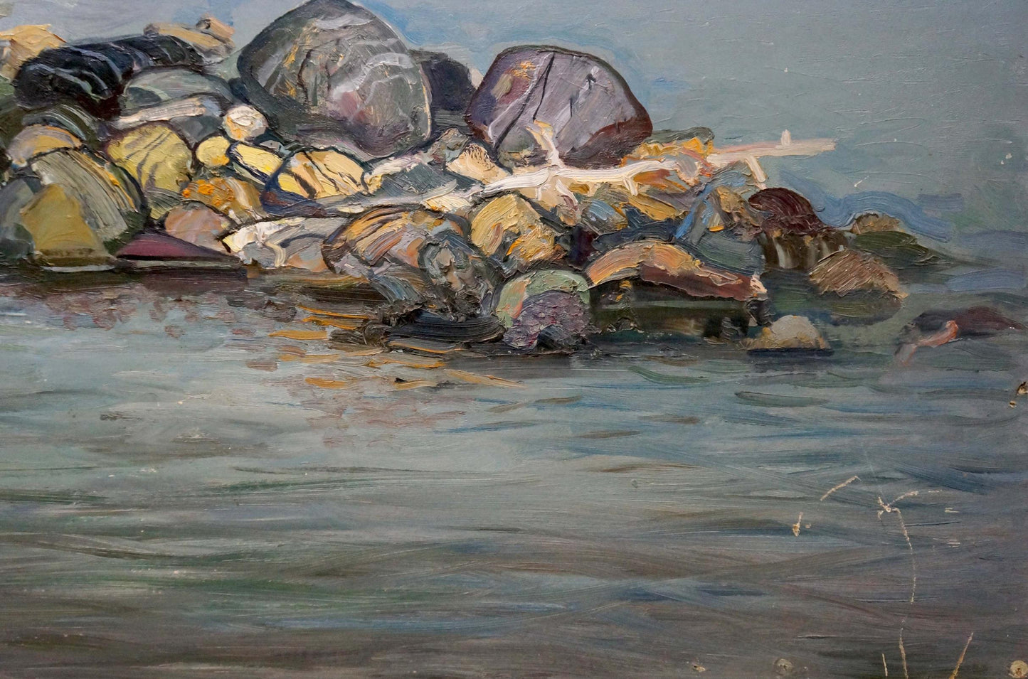 Oil painting On the shore: weathered multicolored rocks at waters edge