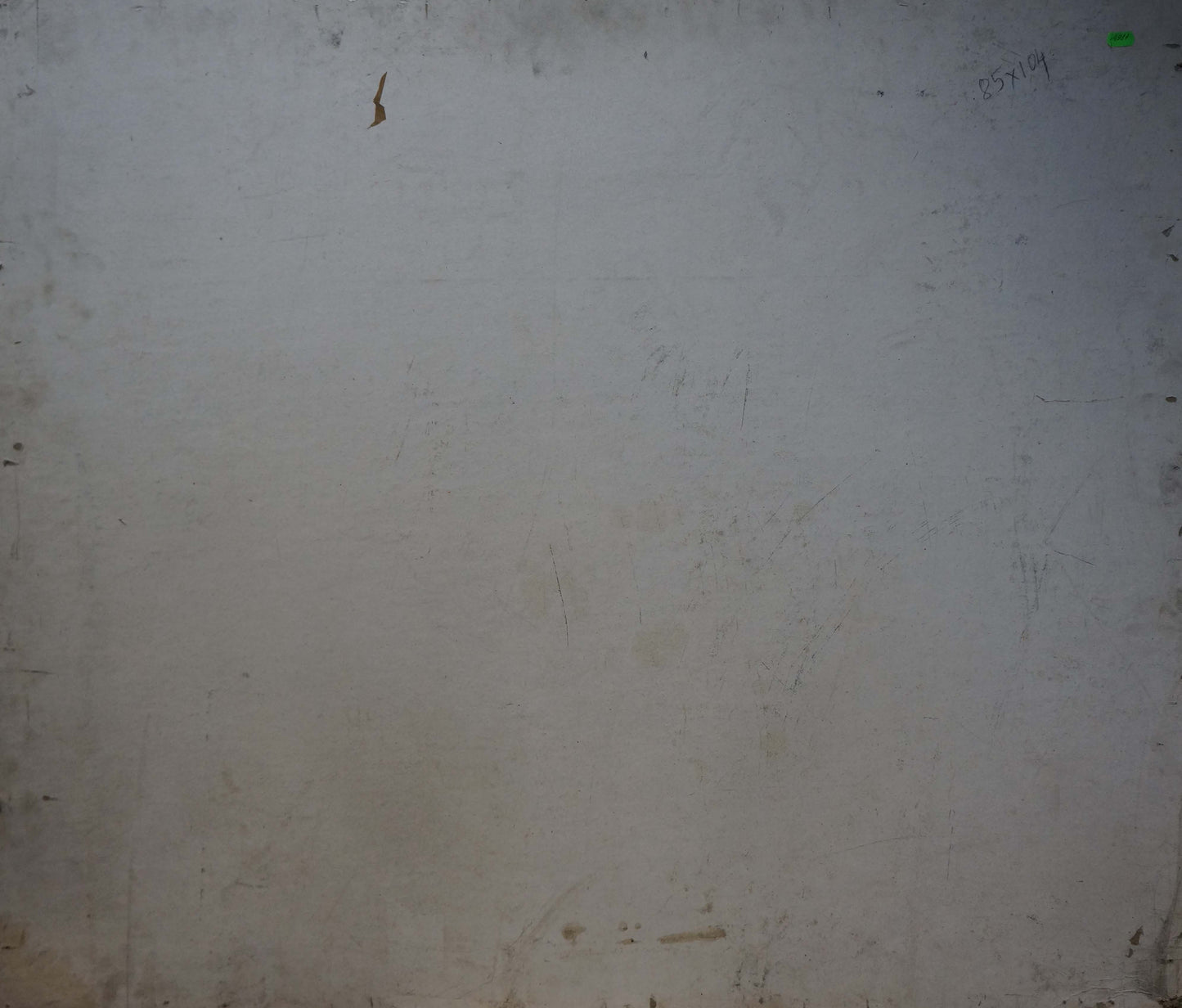Back of oil painting On the shore with worn off-white wall and green sticker