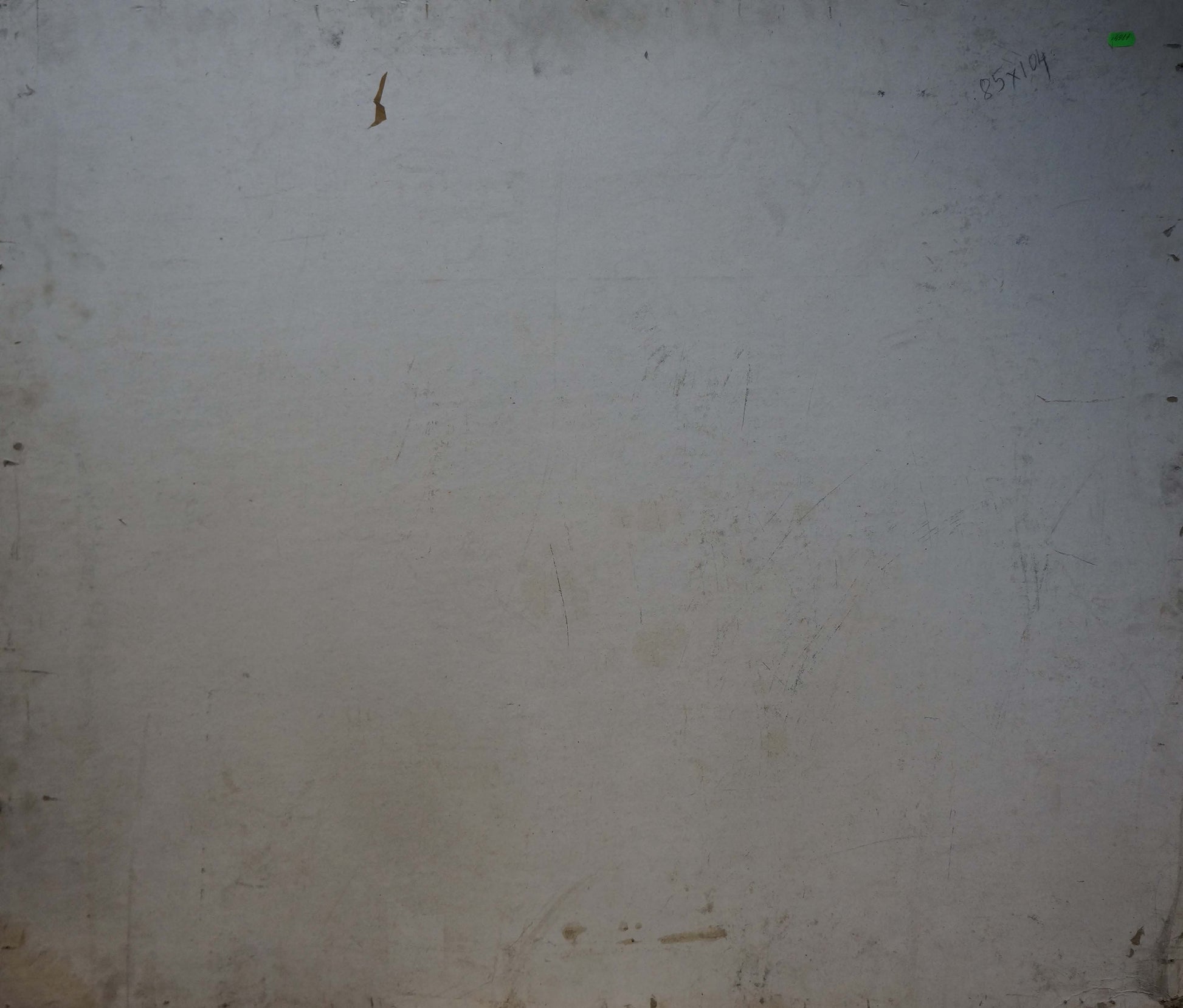 Back of oil painting On the shore with worn off-white wall and green sticker