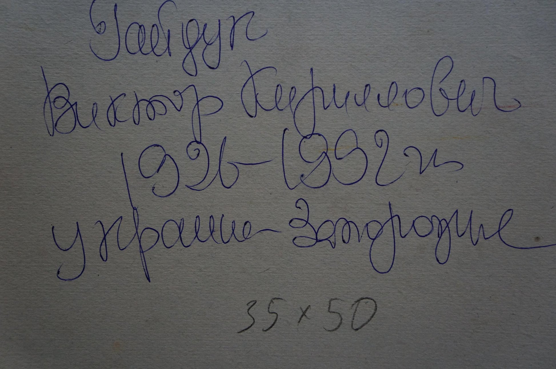 Back of Viktor Gaiduk oil painting landscape with handwritten blue ink inscription on gray surface
