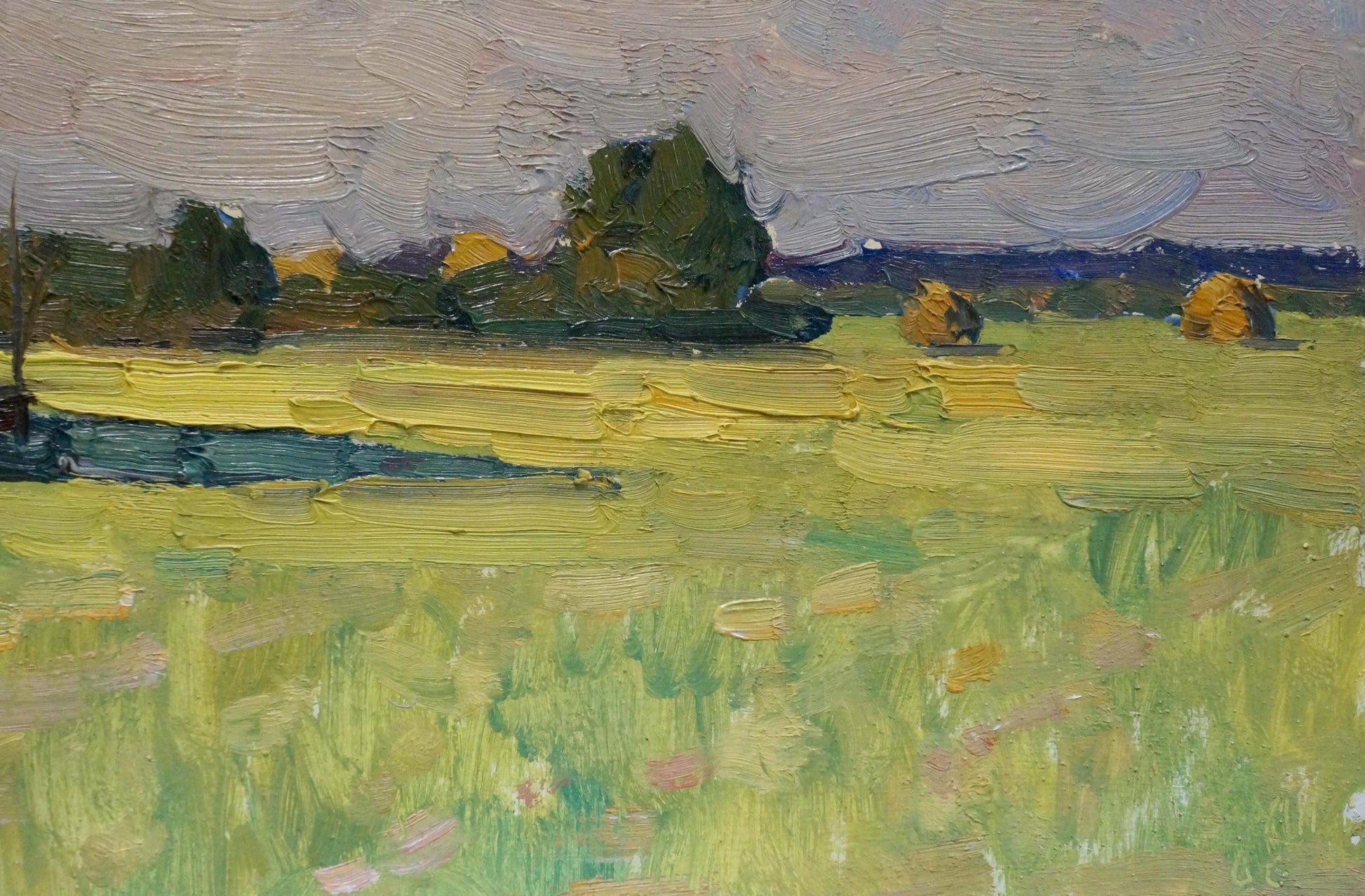 Oil painting Haystacks by Mordovets Andrey Nikitich: vibrant green field with yellow hay bales under soft gray sky