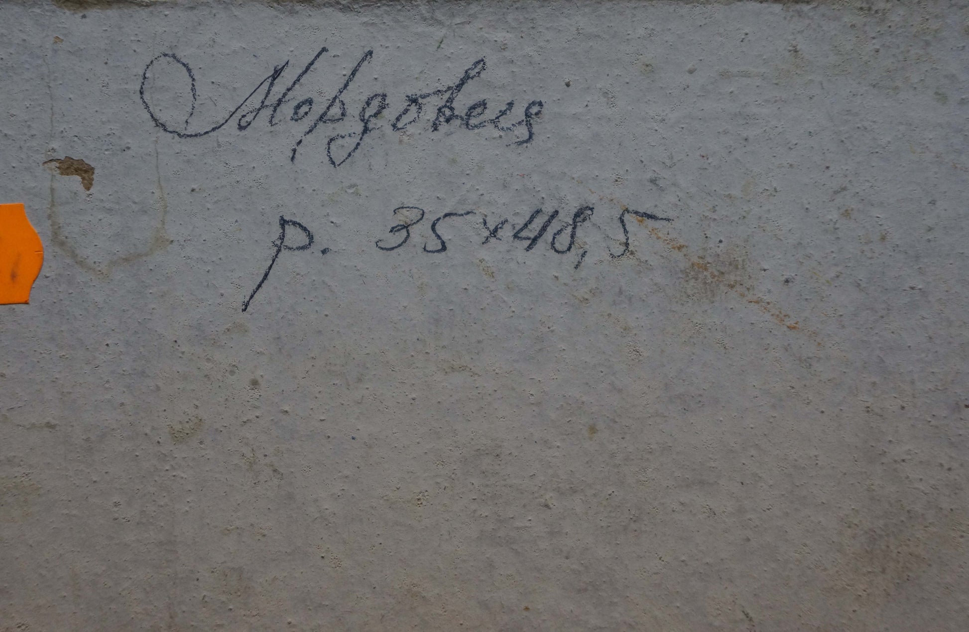 Back of oil painting Haystacks by Mordovets Andrey Nikitich on gray concrete wall with inscription and orange tag