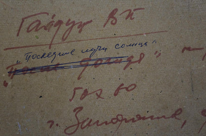 Back of oil painting The last rays of the sun by Gaiduk Viktor Kirillovich with handwritten inscription in red and blue ink on textured beige surface
