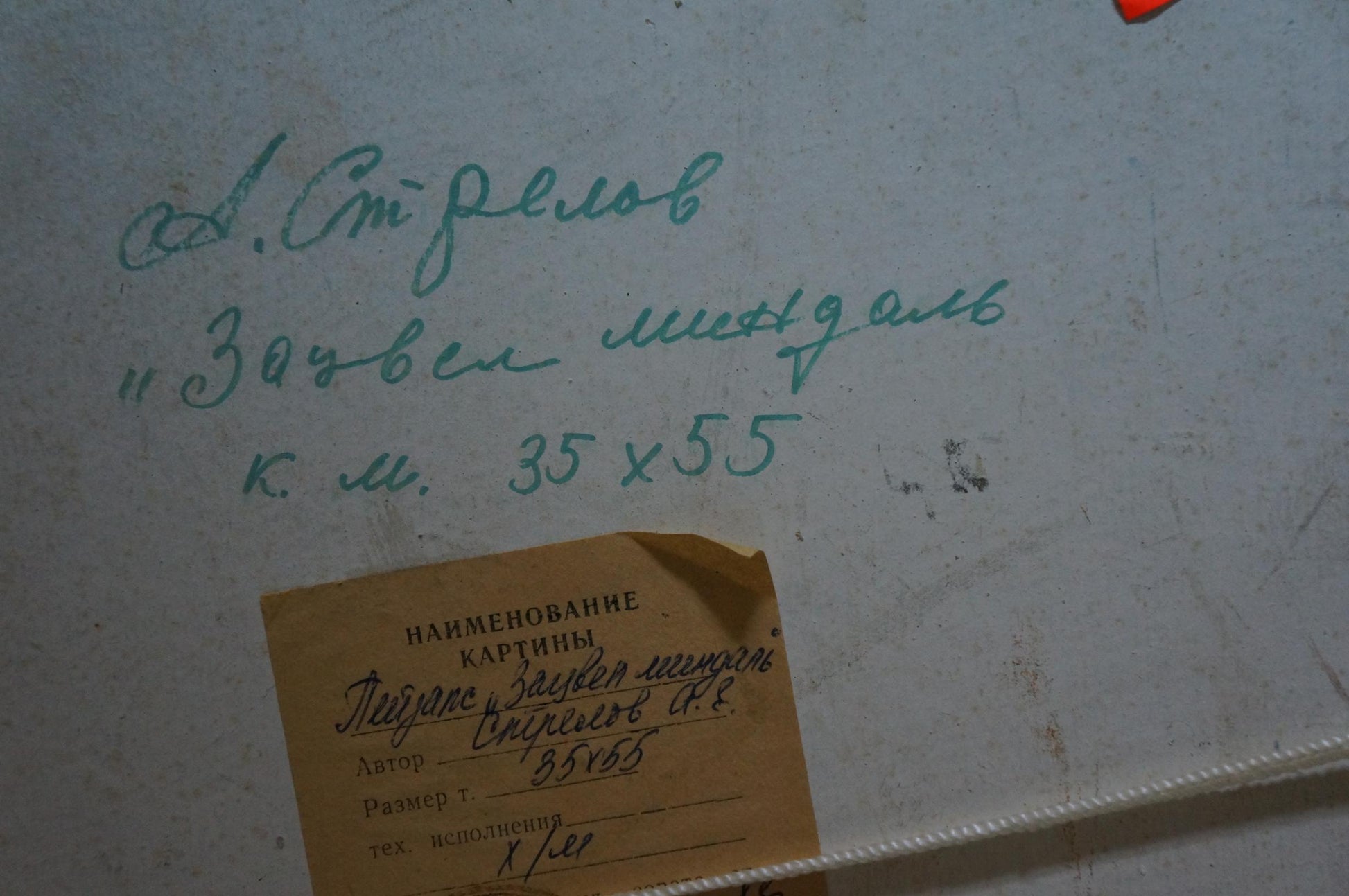 Back of Arkady Strelov mountain landscape oil painting with teal handwritten label and R. tag