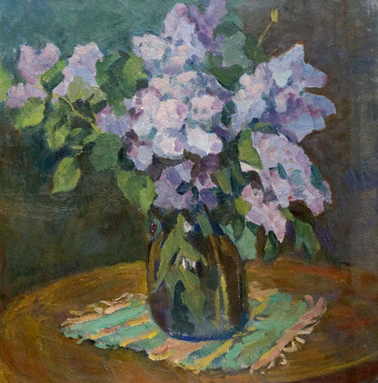 Oil painting of vibrant lilac bouquet in dark green glass vase on wood table