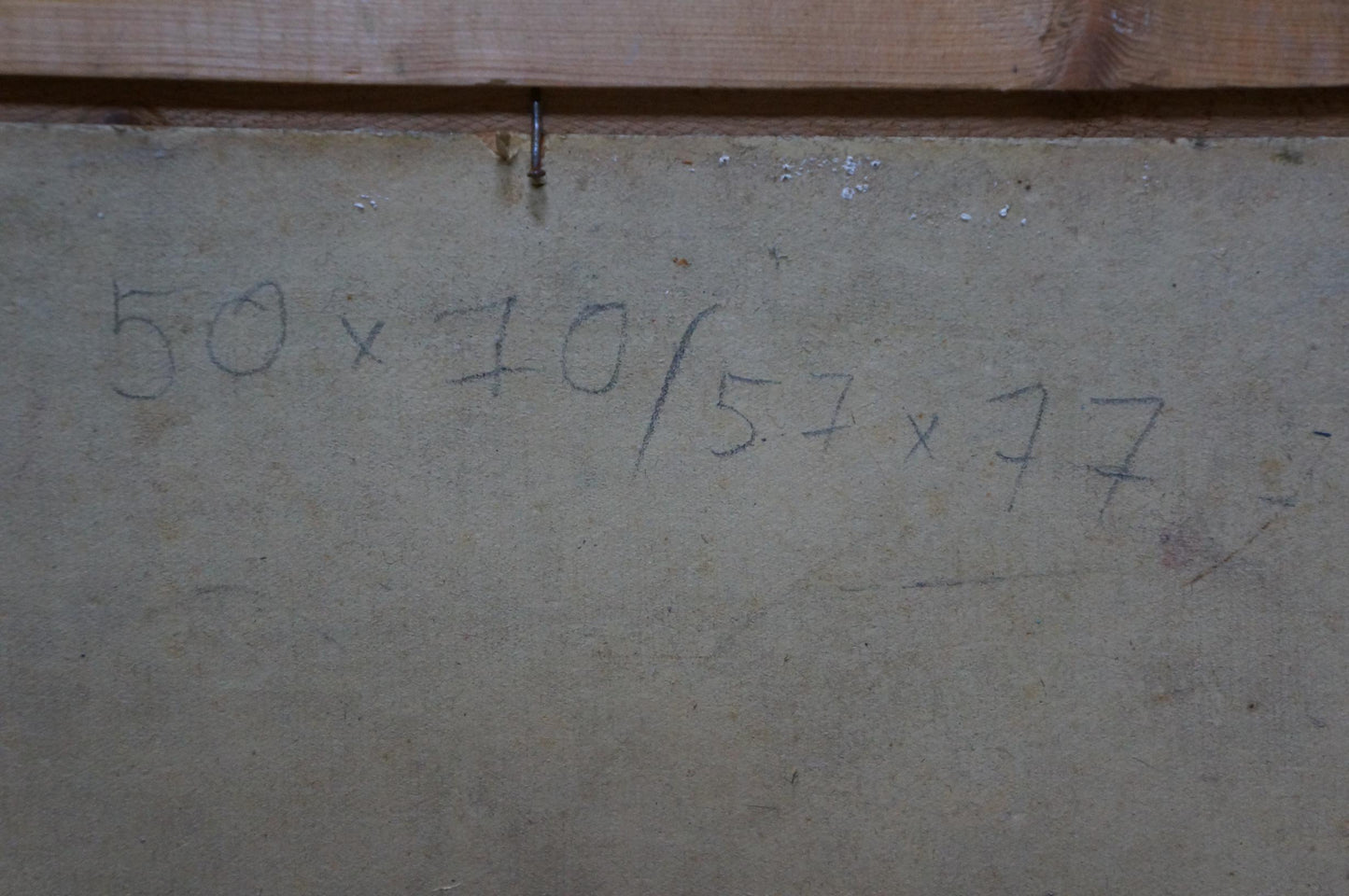 Back of Oil painting In Port Khodchenko Lev Pavlovich with handwritten 50 x 70 / 57 x 77 measurements on gray concrete wall