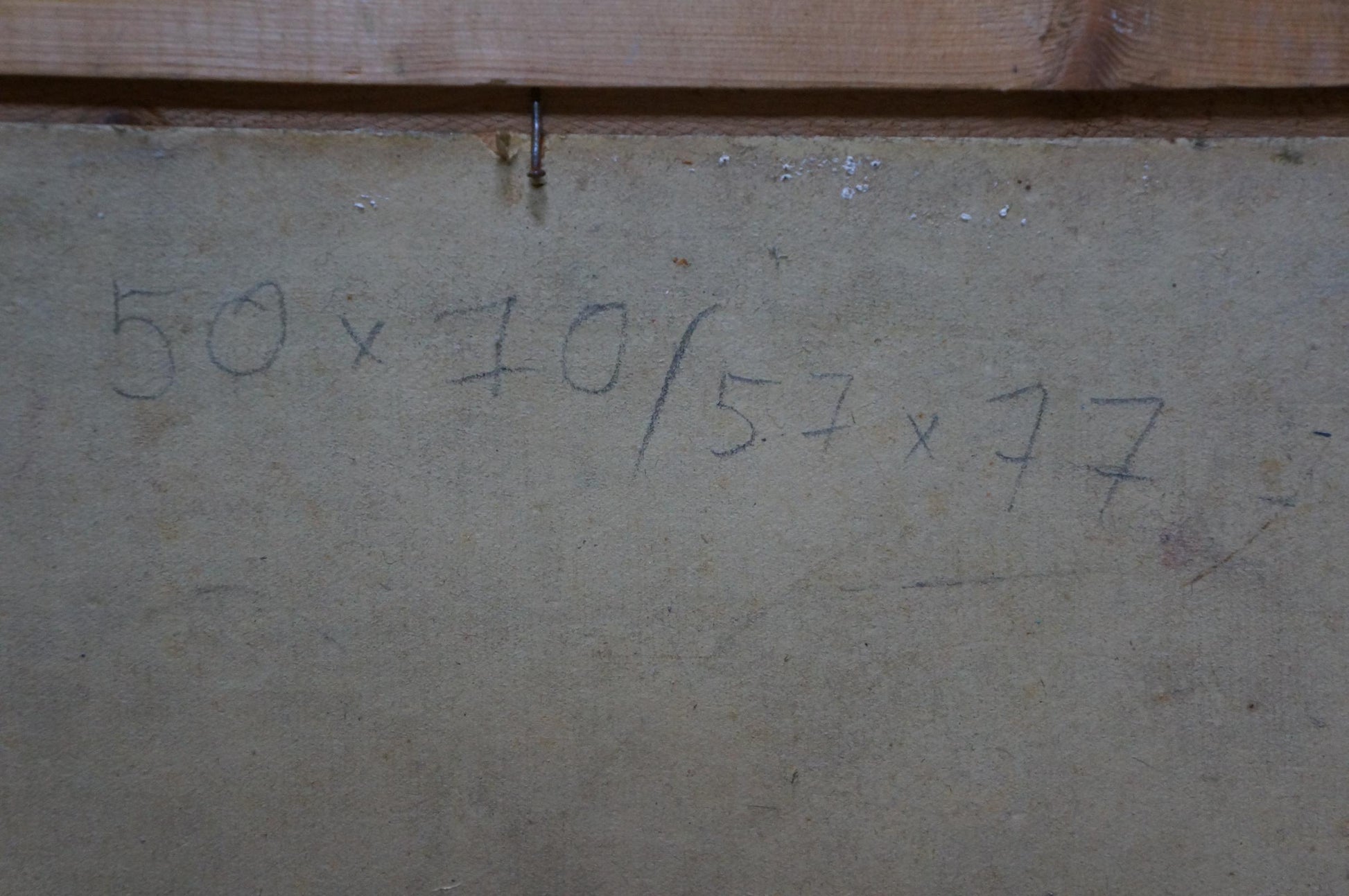 Back of Oil painting In Port Khodchenko Lev Pavlovich with handwritten 50 x 70 / 57 x 77 measurements on gray concrete wall