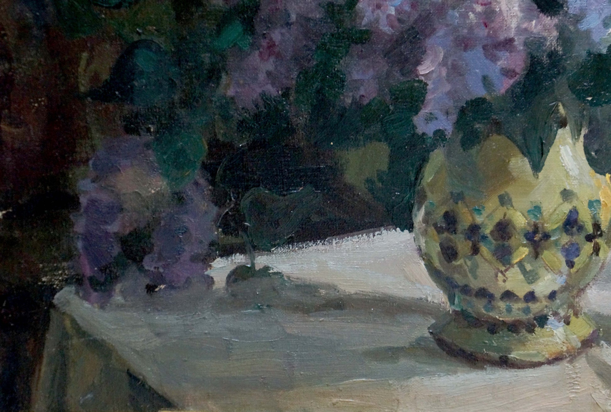 Yellow ceramic vase with blue-green floral motifs holding purple lilacs by Alexander Khorov
