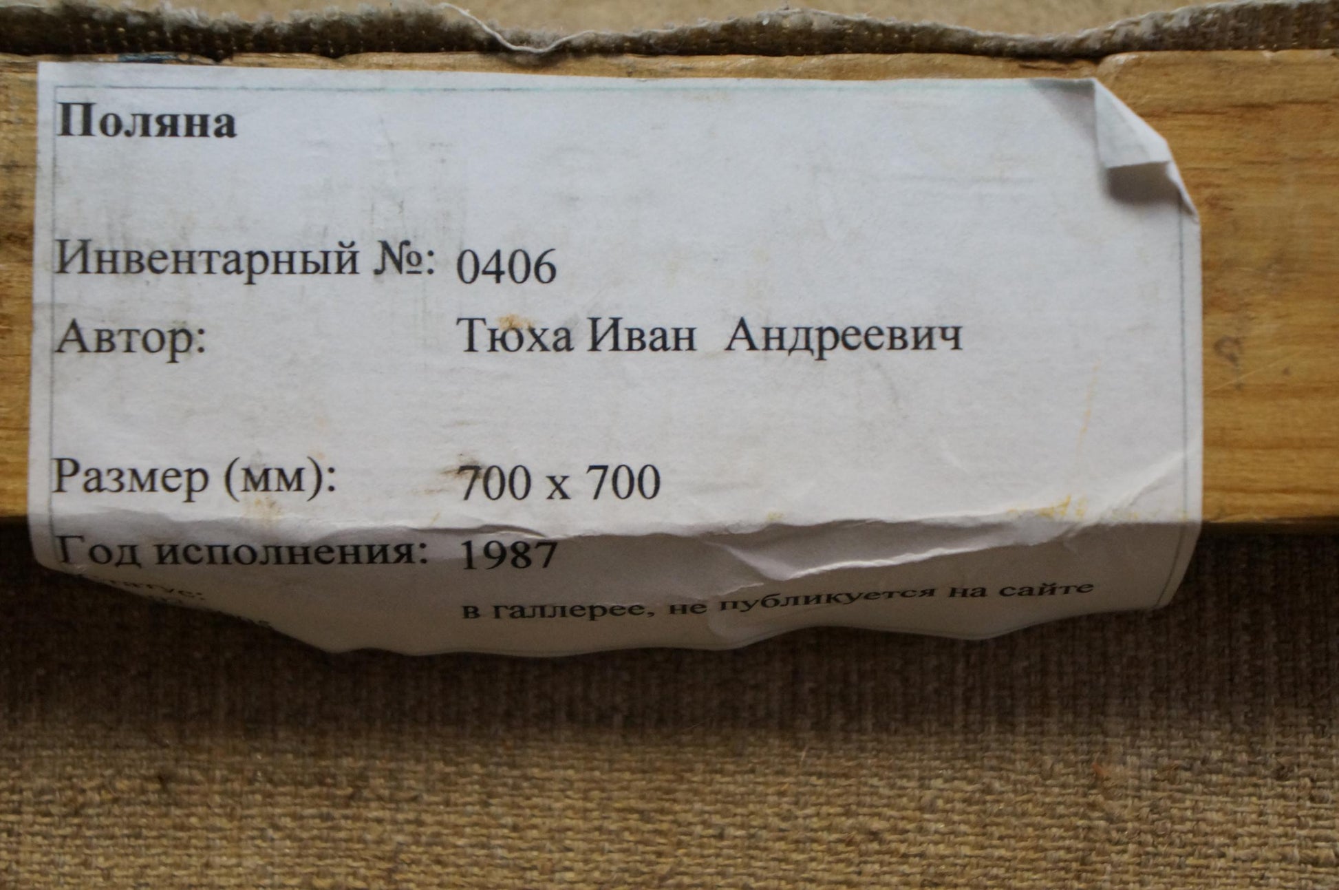 Worn white paper label with black cyrillic text detailing inventory number, author name, dimensions, and year of creation.