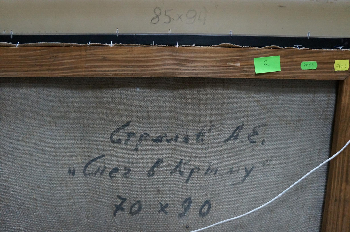 Back of framed oil painting Snow in the city by Strelov Arkady Efimovich with Cyrillic script on gray canvas