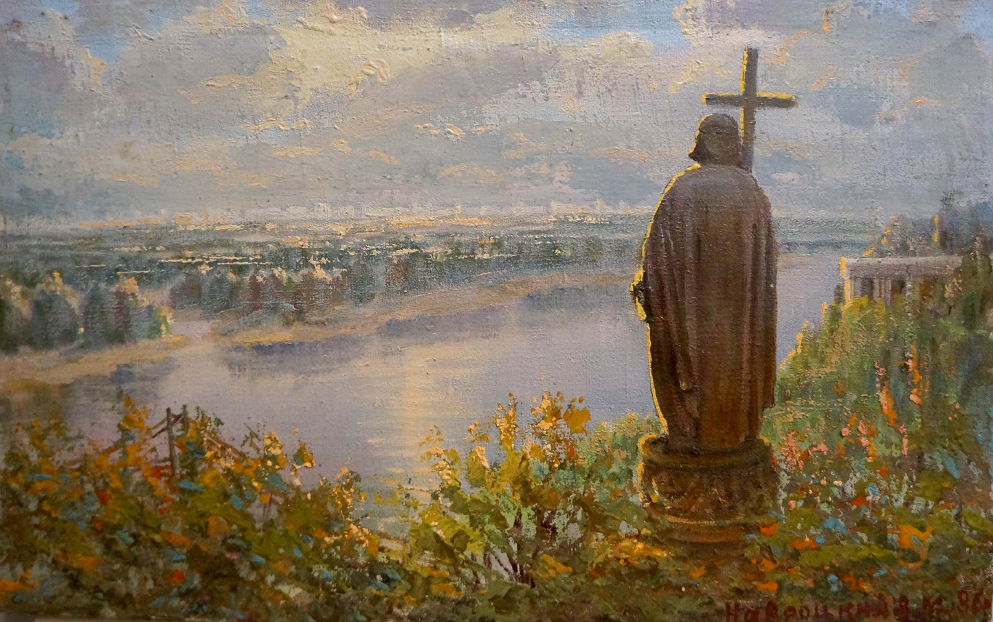 Bronze statue of Saint Vladimir with cross amid autumn foliage