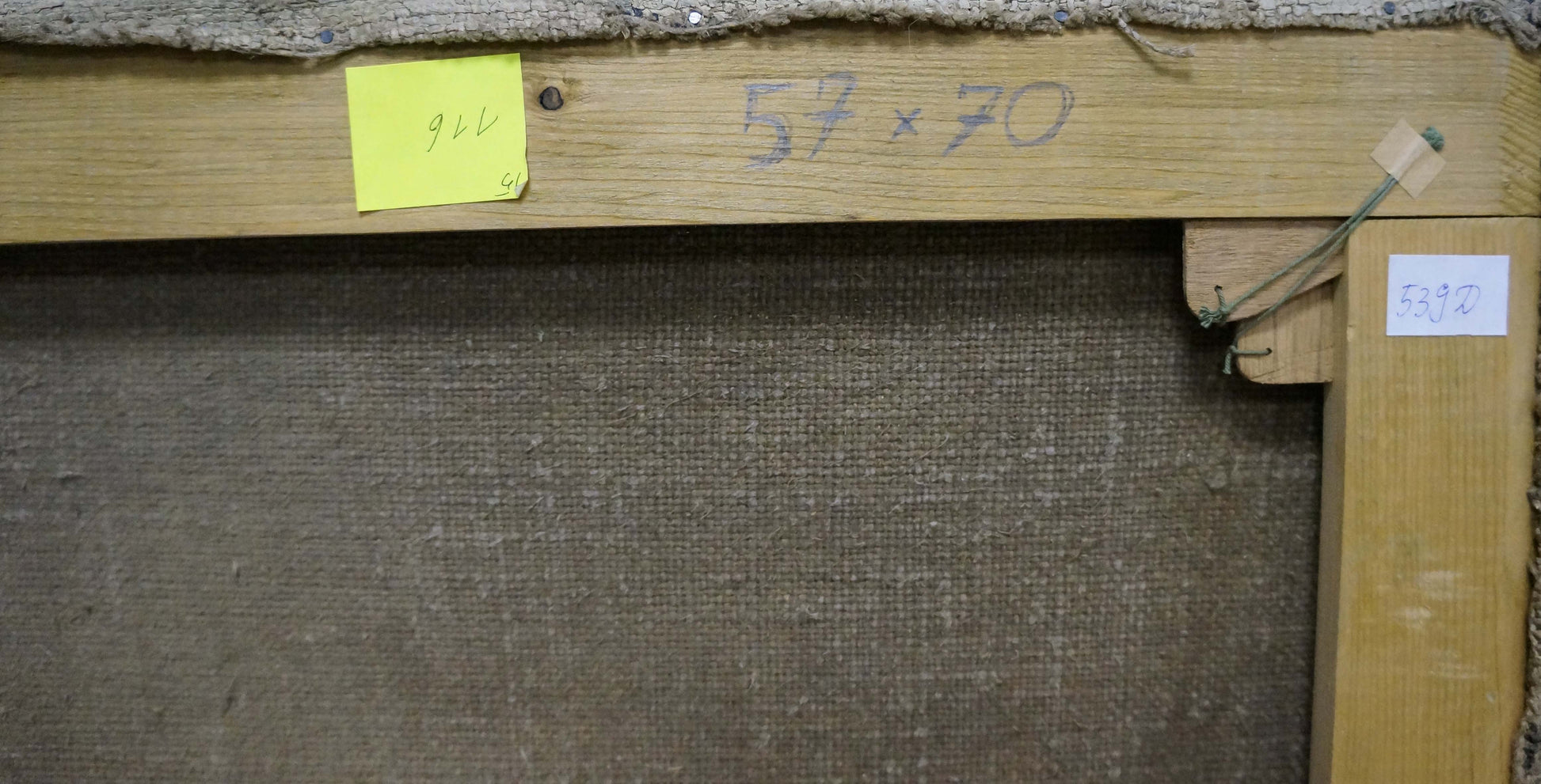 Back of wooden-framed oil painting with beige linen backing and dimensions marked
