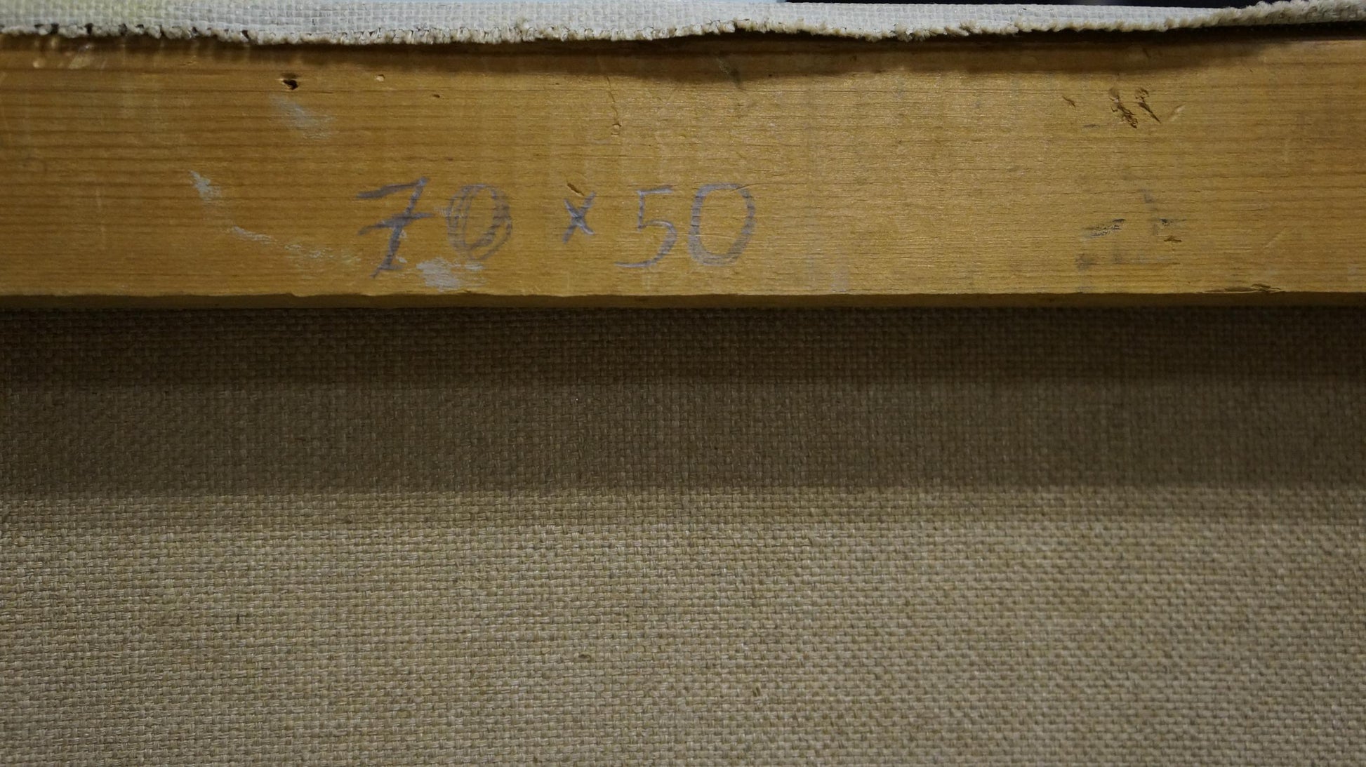 Back of Oil painting By the Sea by Puzyrkov: light brown wooden stretcher bar with faded graphite dimension markings