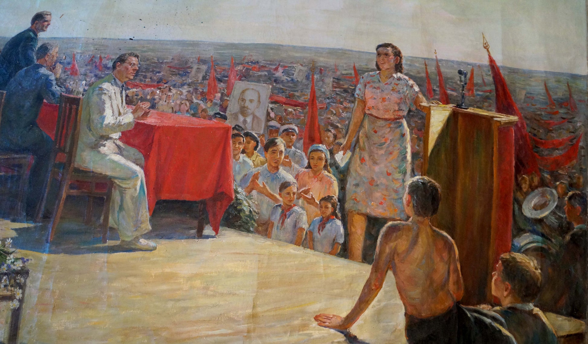 Oil painting of woman in floral dress at podium under red flags by Petr Kuzmich Stolyarenko