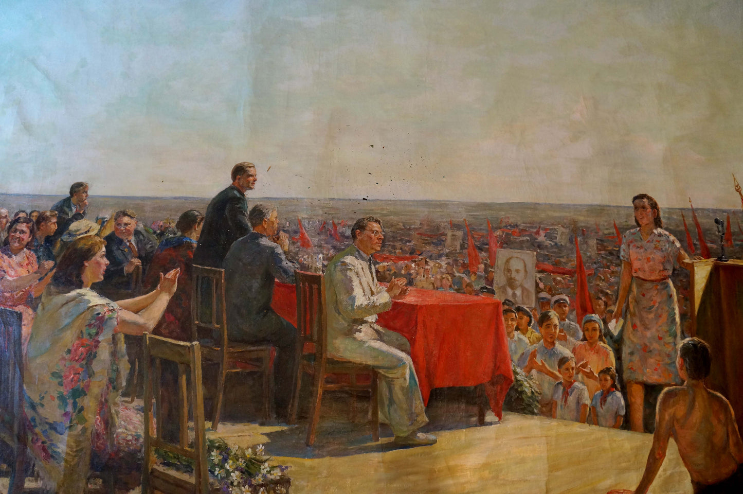 Oil painting by Petr Kuzmich Stolyarenko: vibrant red tablecloth on wooden table at rally gathering