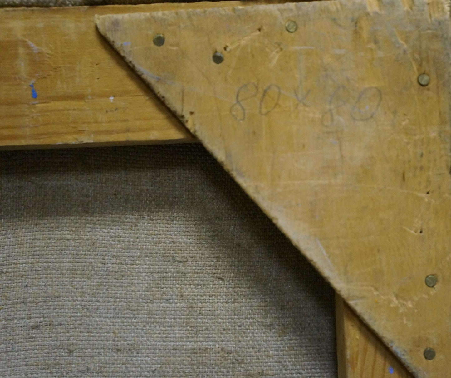 Back of oil painting Sunflowers by Kolomoitsev Petr Mikhailovich with worn wooden triangular support bracket, visible screws and faded pencil markings