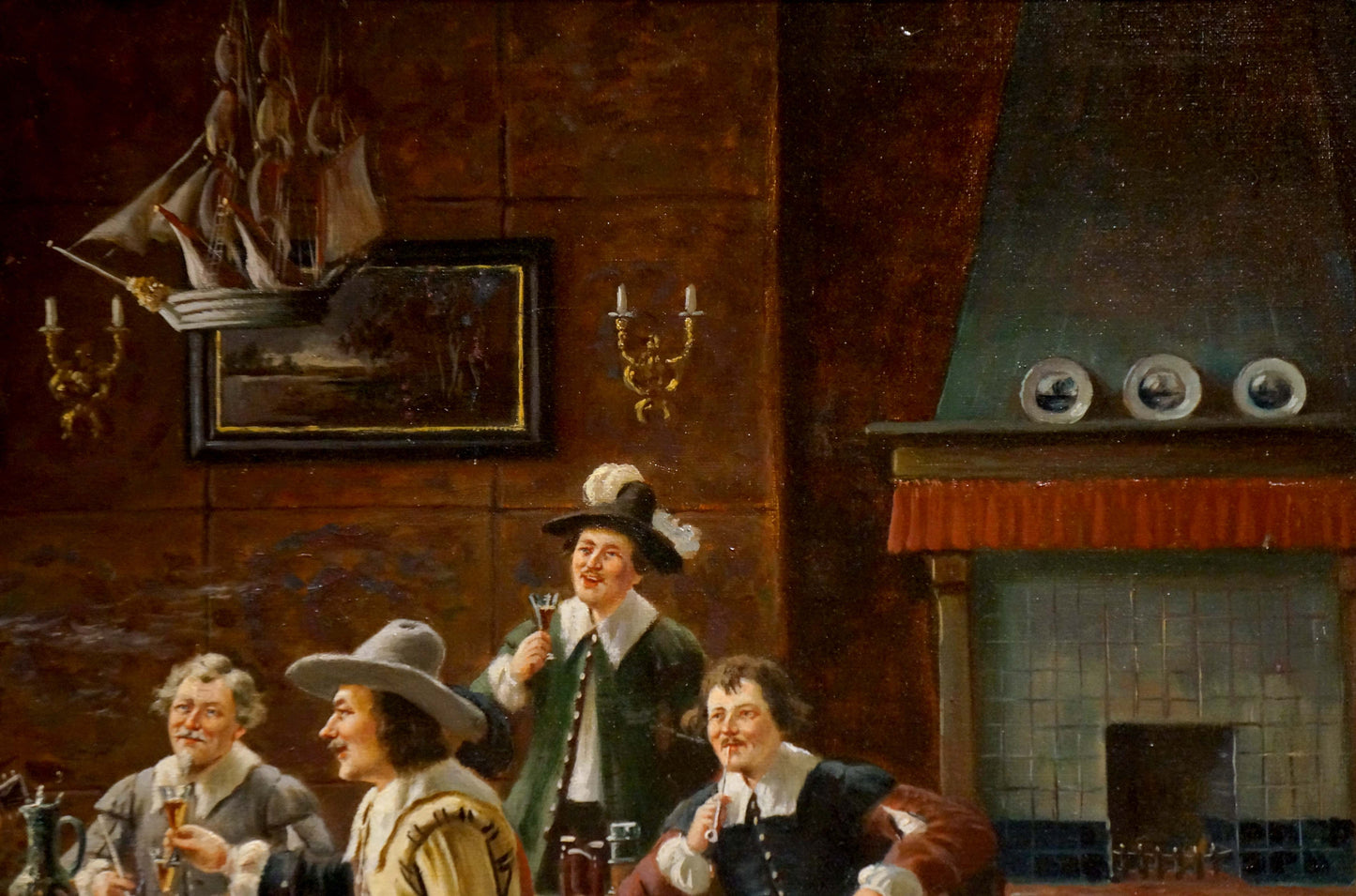 Framed oil painting of sailing ship above ornate candelabras