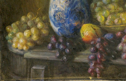 Oil painting of blue white floral vase amid green purple yellow grapes