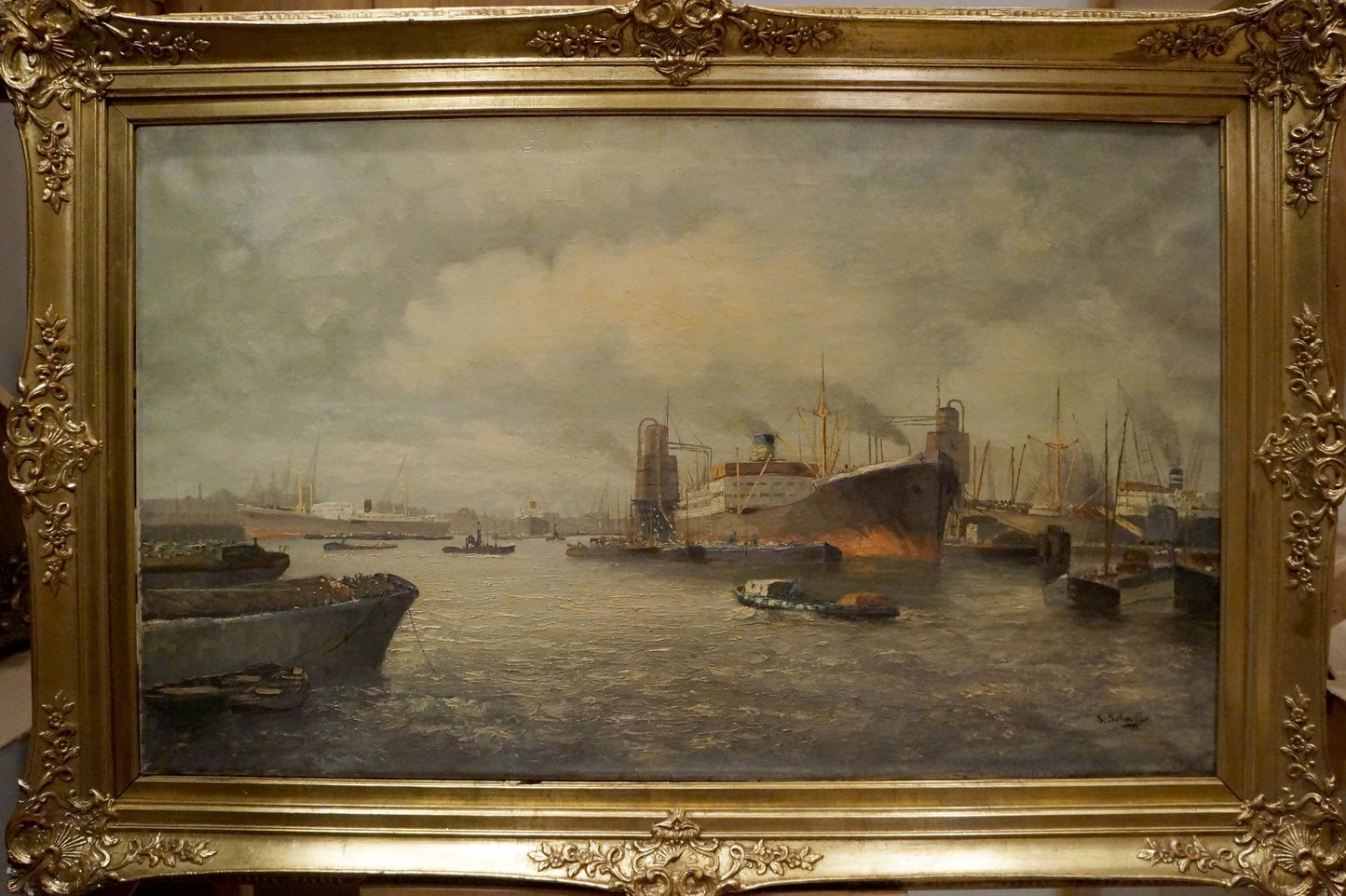 Ornate gold-framed oil painting of bustling harbor with ships under overcast sky