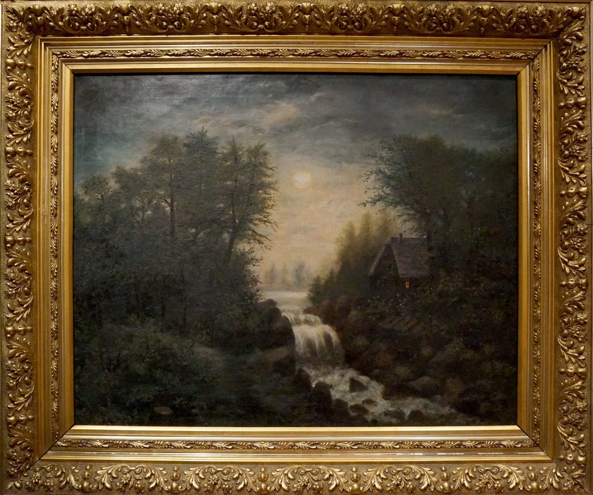 Ornate gold-framed oil painting of moonlit forest with waterfall and cabin