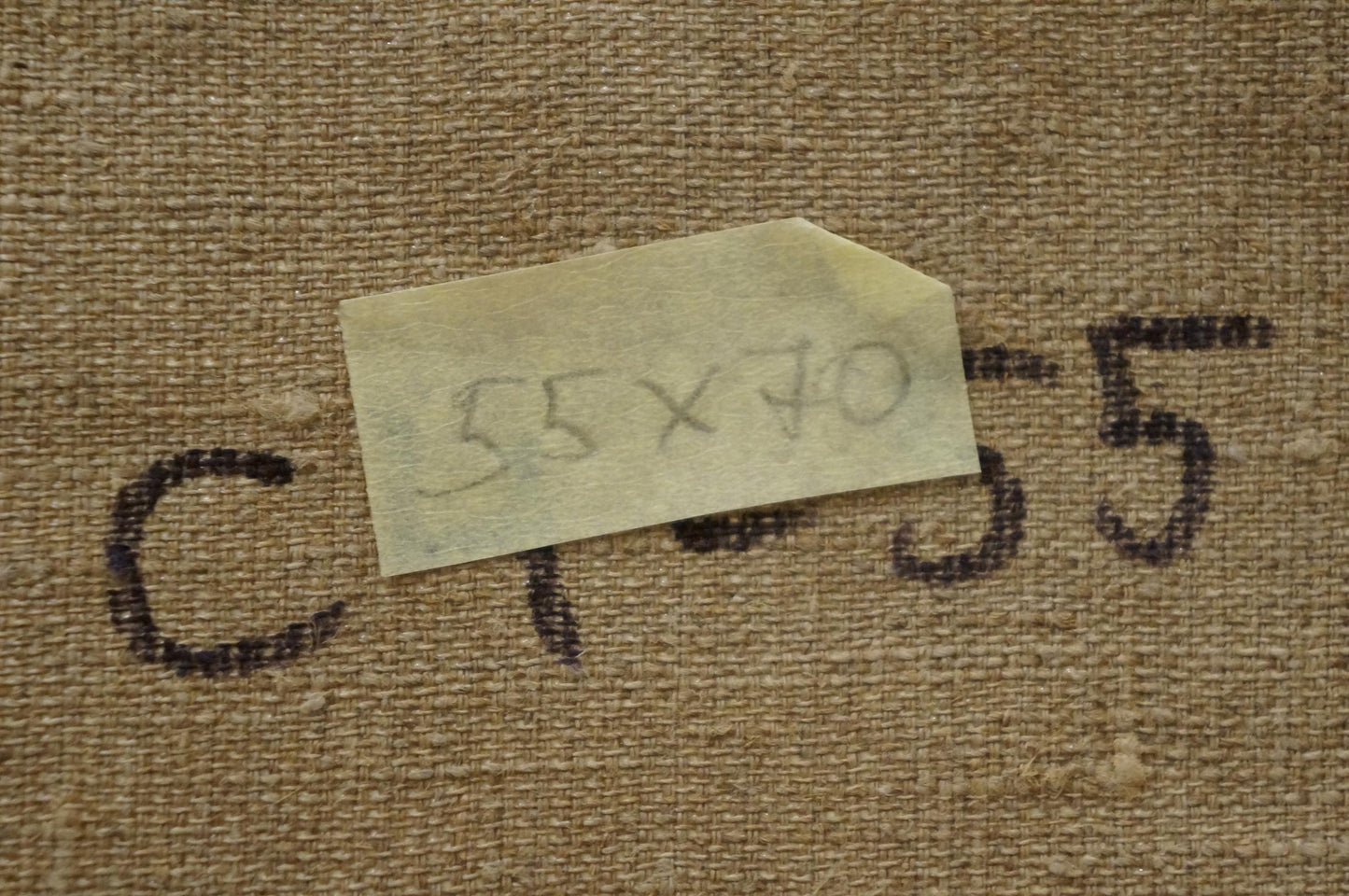 Back of Nikolay Vladimirovich Chernikov oil painting with beige textured fabric, yellow sticky note and black ink markings