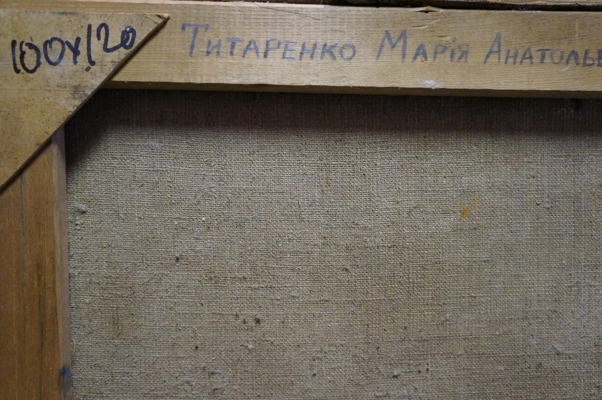 Back of Oil painting Gypsies by Maria Titarenko, beige canvas weave and blue signature