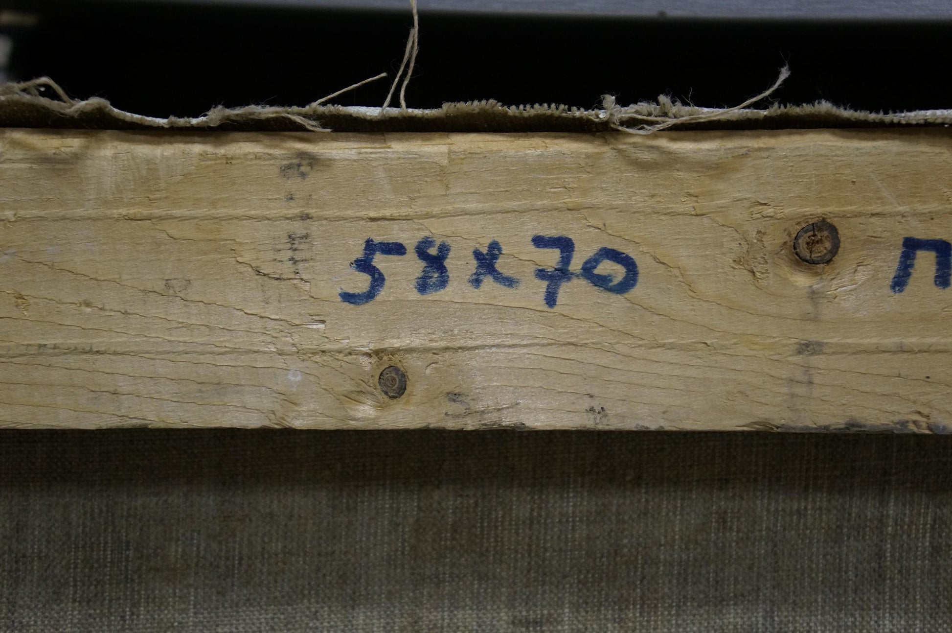Back of Oil painting Near the forest Mynka Alexander Fedorovich: weathered wooden beam with rusted screws and blue markings