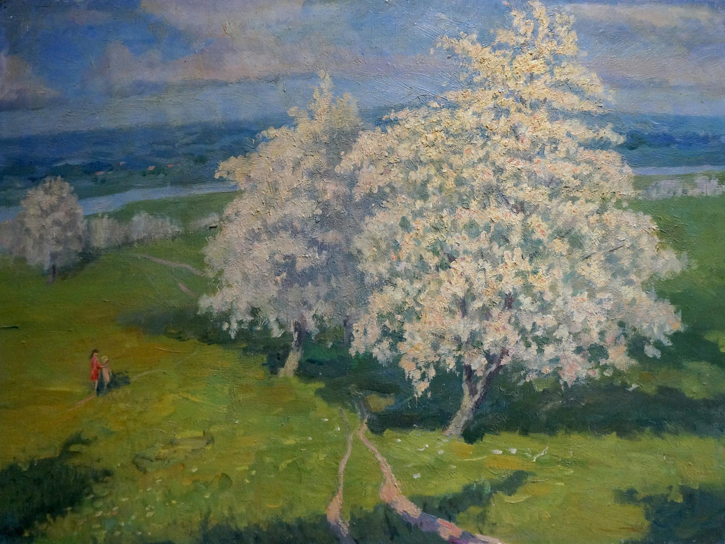 Oil painting of blooming white tree on green grass with hills and blue sky