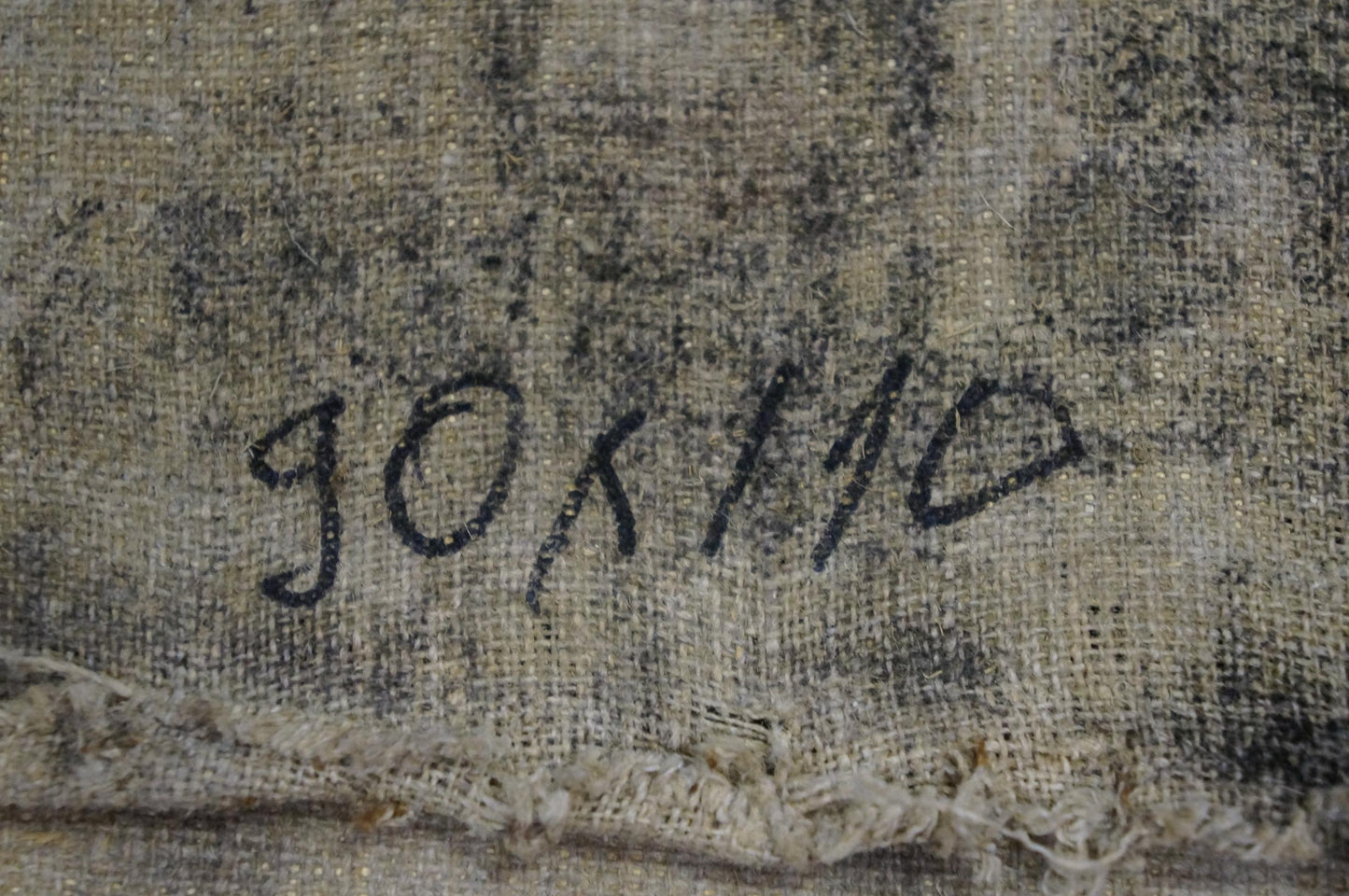 The image shows a faded, textured canvas with the handwritten signature ’gokilo’ in black ink.