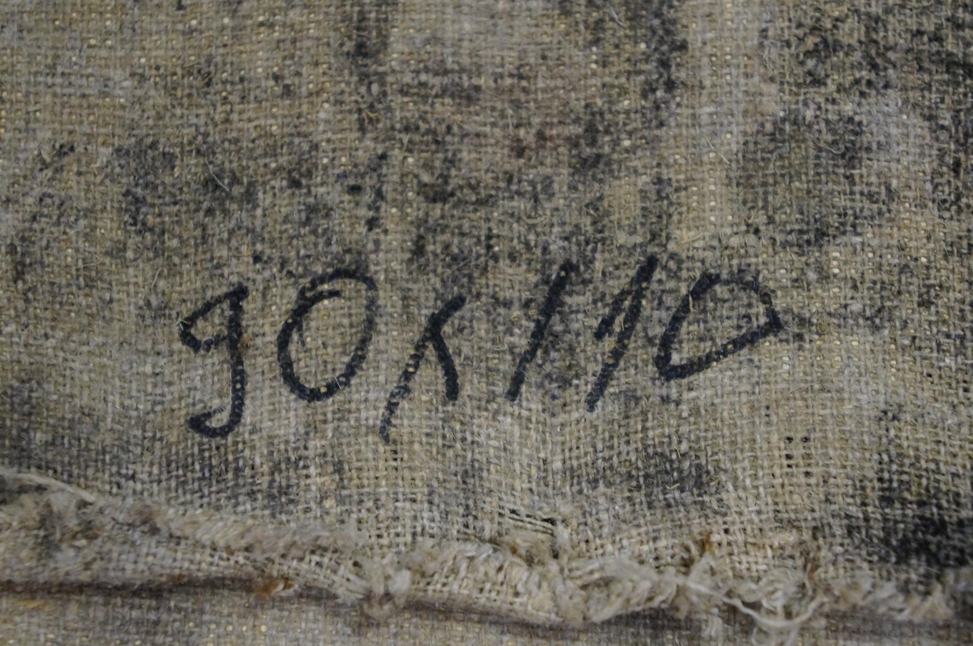 The image shows a faded, textured canvas with the handwritten signature ’gokilo’ in black ink.