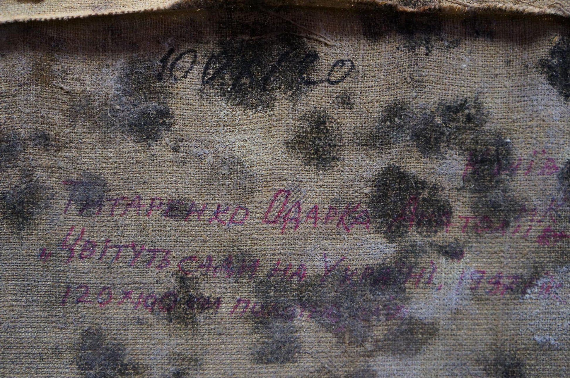 Back of oil painting Blooming trees by Tytarenko Odarka Anatoliivna, worn beige fabric with faded Cyrillic text