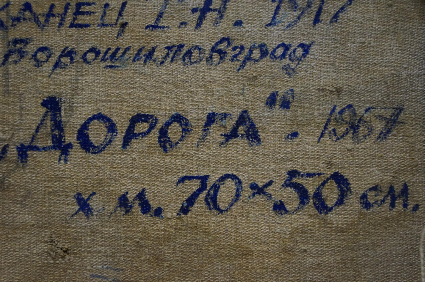 Back of oil painting Road to the Mountains by Kapkanets Tamara Nikitichna with worn beige canvas and faded blue Cyrillic text