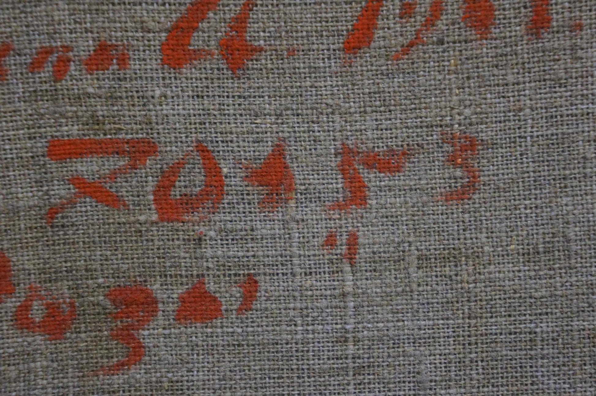 Back of Artur Sarkisyan Red Roses oil painting: gray woven fabric with faded red markings