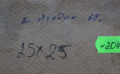 The image shows a textured, beige-colored paper surface with handwritten markings and a green label.