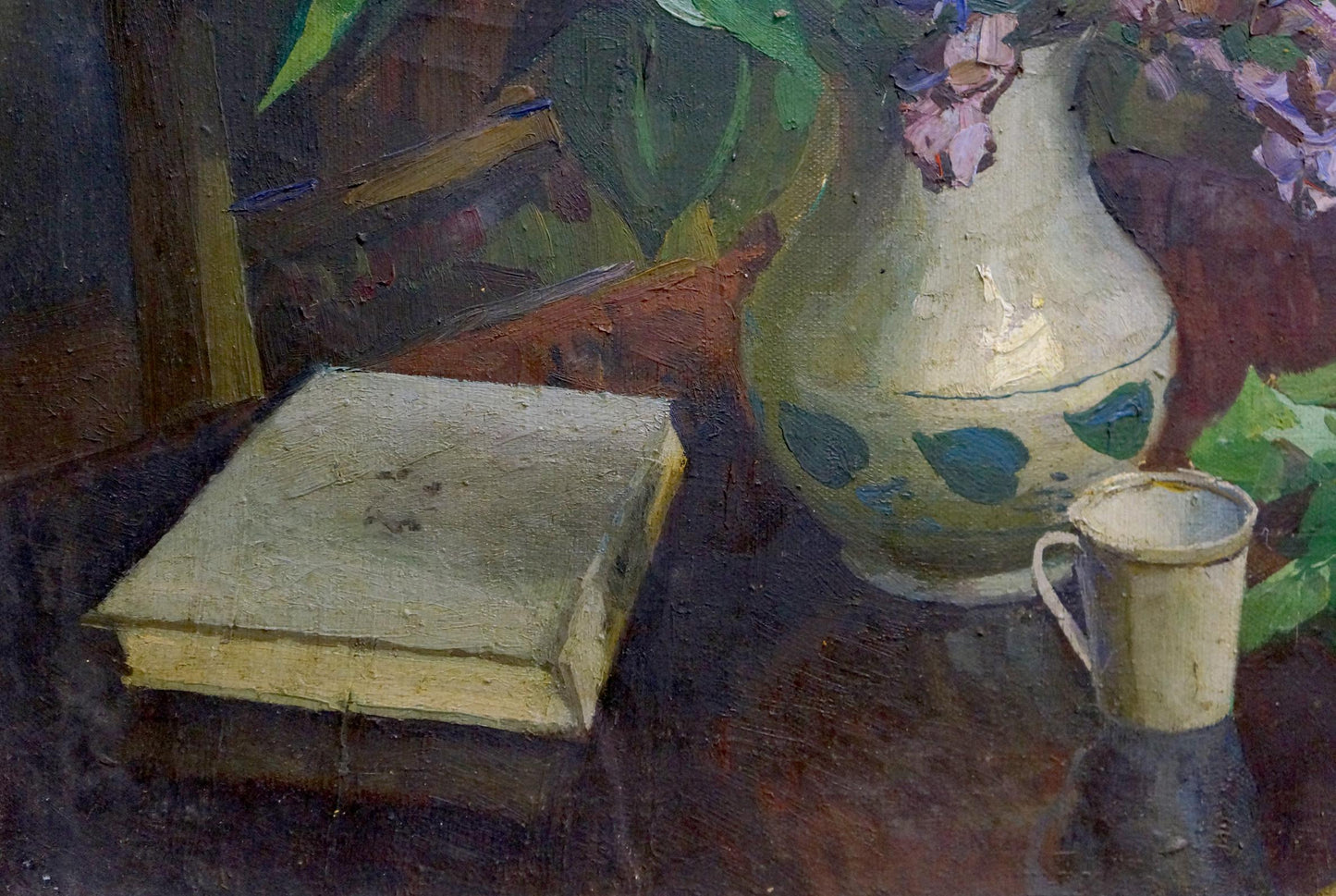 Cream ceramic vase with green leaves in Lilac and book oil painting display