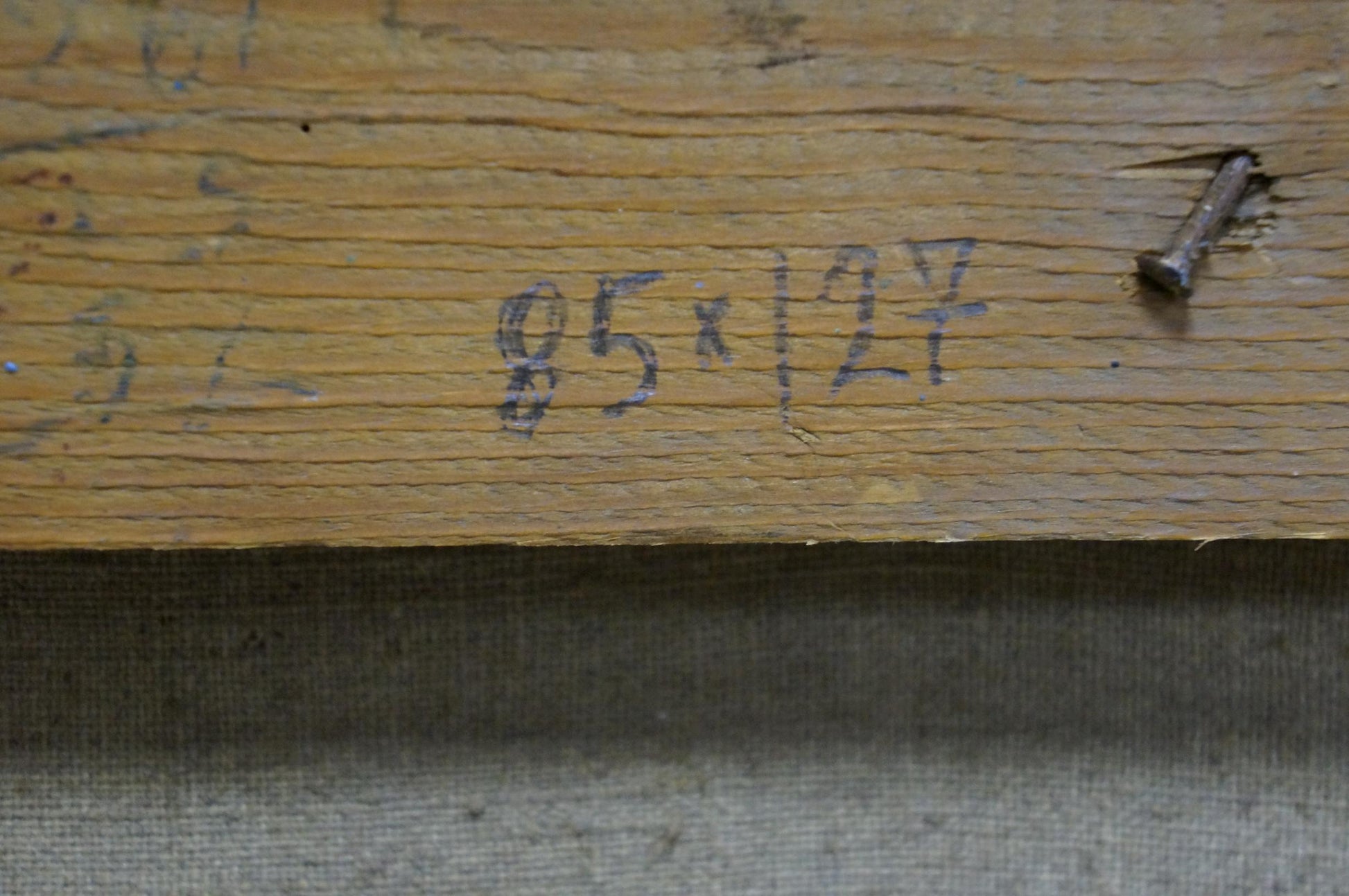 Back of Sevets Victor Stepanovich oil painting: worn plank with faded markings, rusted nail