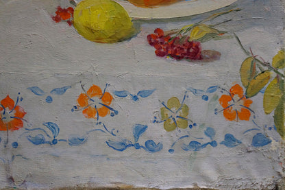 Oil painting by Kapkanets Tamara Nikitichna: yellow lemon, red berries on floral tablecloth