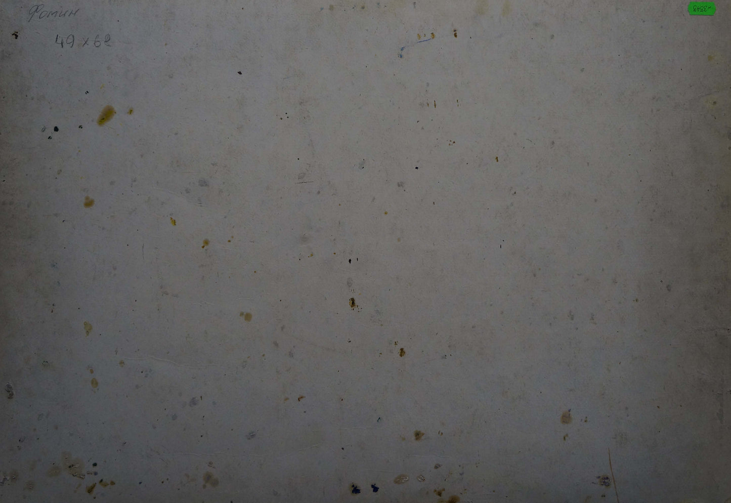 A weathered off-white surface with scattered dark and yellowish stains.