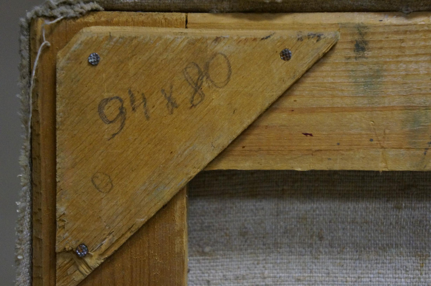 Back of oil painting by Kompaniyets-Kiyanchenko with worn yellow wooden corner bracket and hand-scribed dimensions