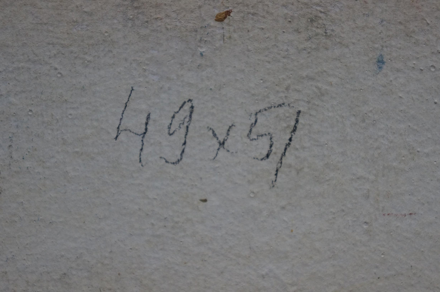 Black chalk markings on gray concrete wall behind colorful roses oil painting