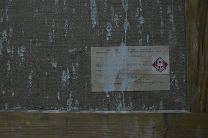 Back of Yuri Fedorovich Zlyden oil painting with weathered label on gray wall