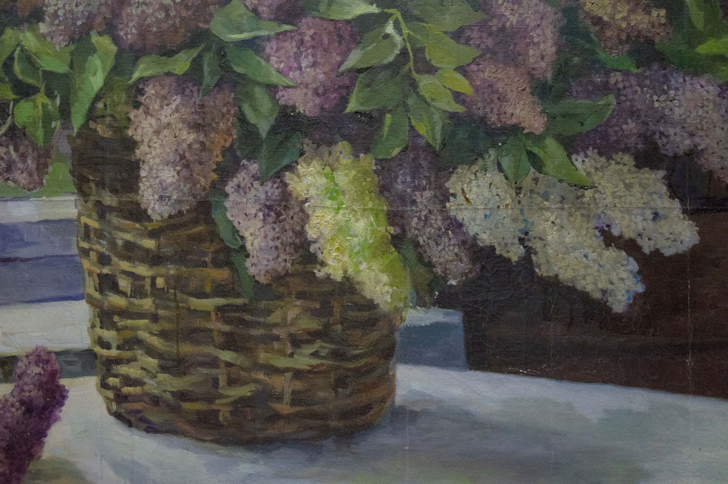 Oil painting of lilac near window in woven basket with purple white blossoms