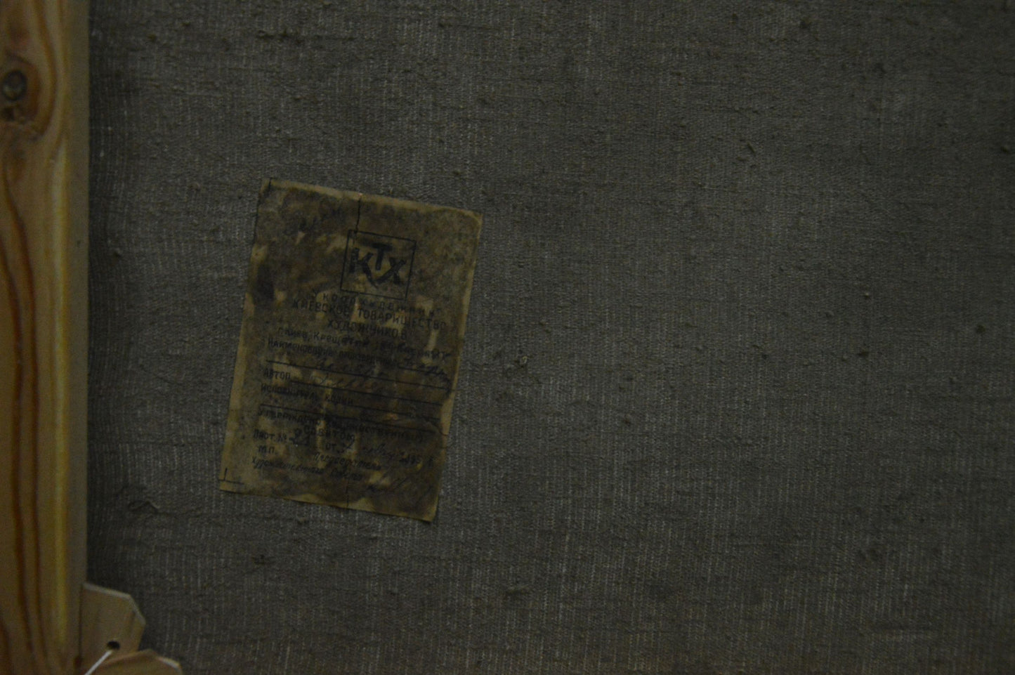 Back of Oil painting Wooded Mountainscape faded yellow label on gray surface