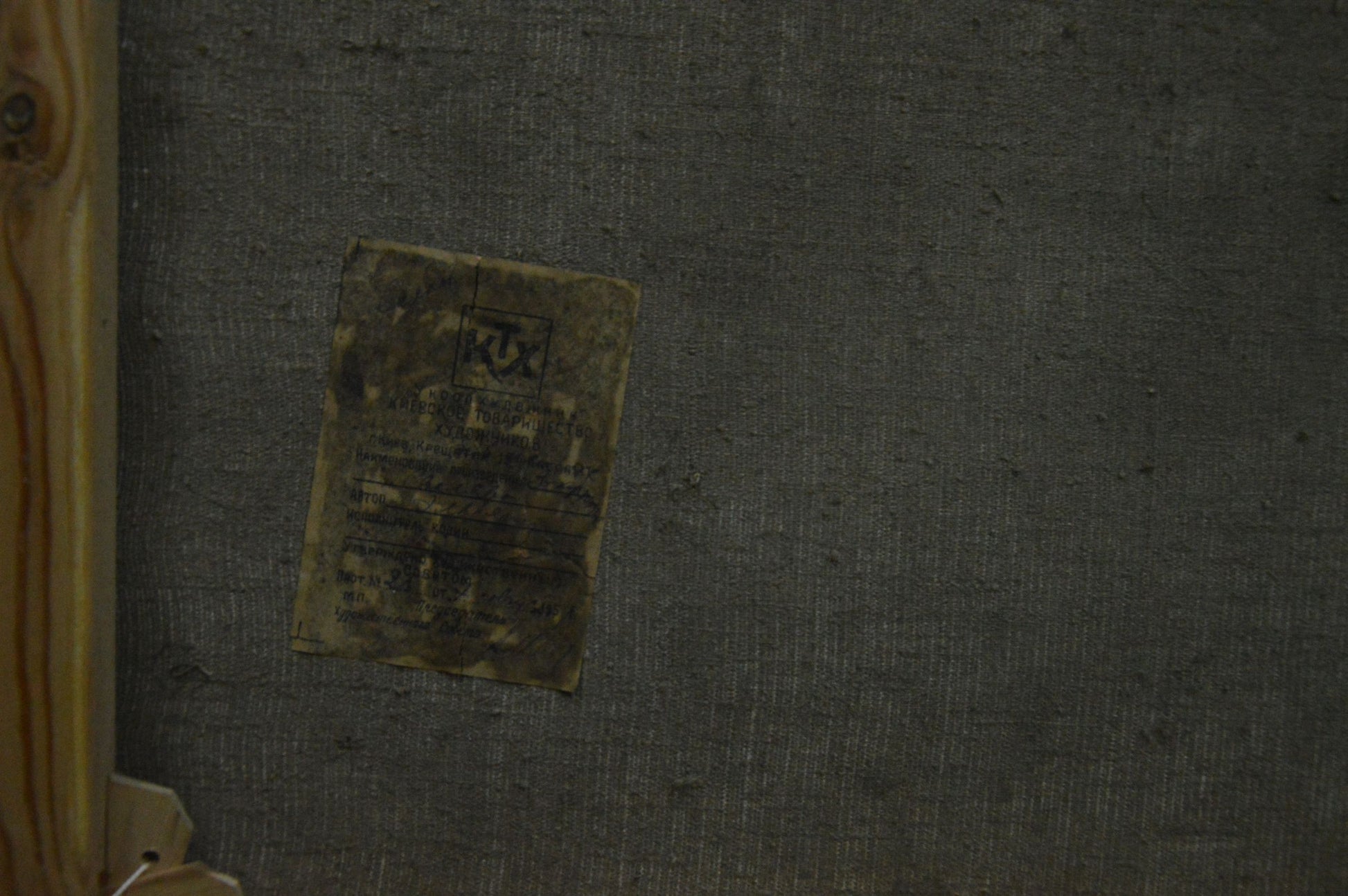 Back of Oil painting Wooded Mountainscape faded yellow label on gray surface
