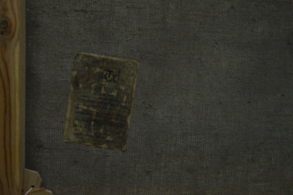 Back of Oil painting Wooded Mountainscape faded yellow label on gray surface