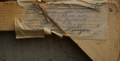 Back of Skripin oil painting Still life: torn beige label with Cyrillic text on wood