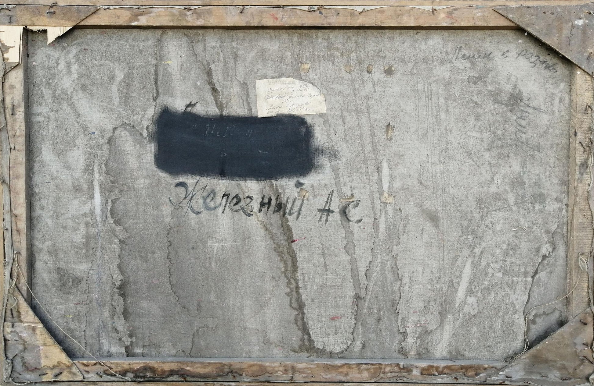 Back of Social realism oil painting: weathered gray canvas with black rectangle, Cyrillic script, aged wood frame