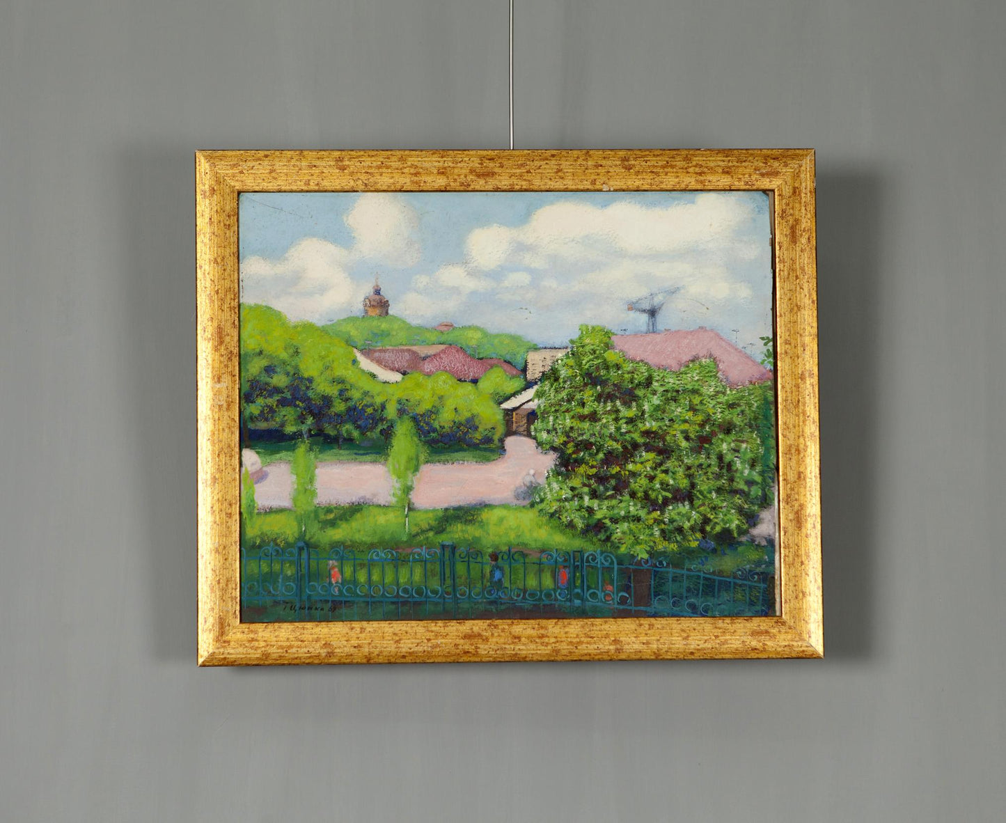 Oil painting of summer village landscape with green hills, pink roofs, blue fence in gold frame