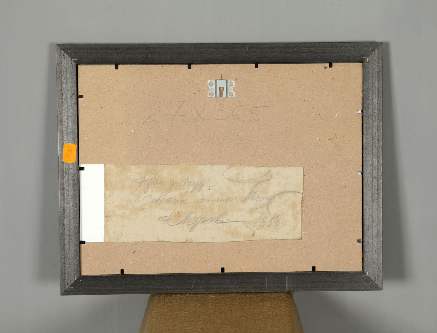 Back of dark gray wooden frame for Oil Painting Oaks by the Pond with beige backing and handwritten note